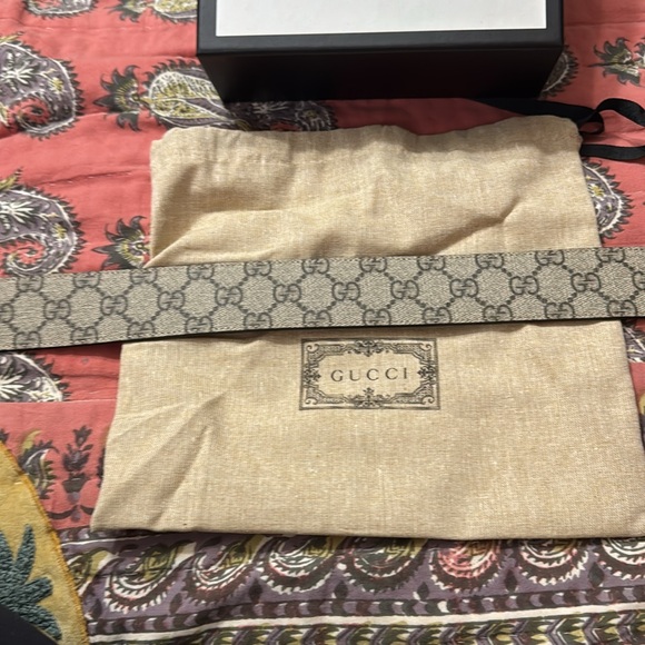 Tan gucci belt, with gold gucci sign, and black and brown gucci imprint on it. - Picture 4 of 11